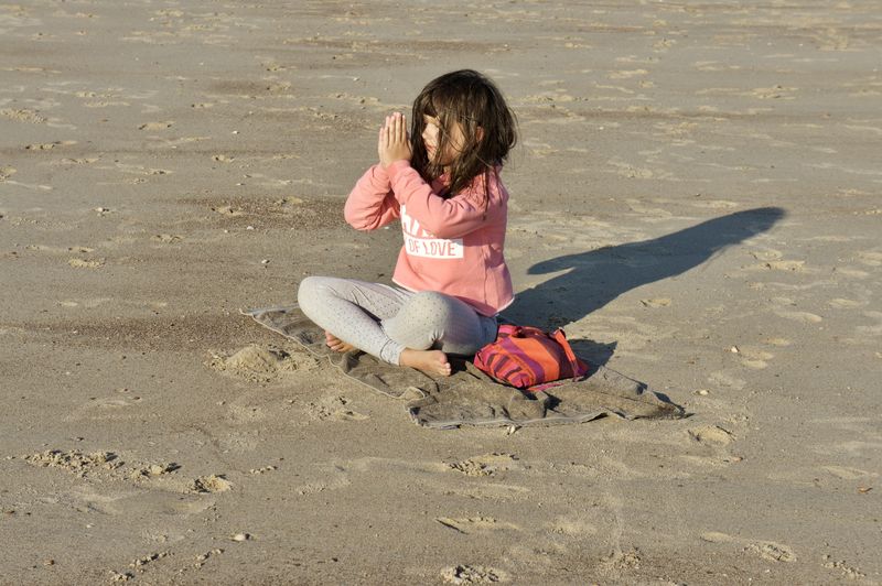 Girl practicing yoga at beach