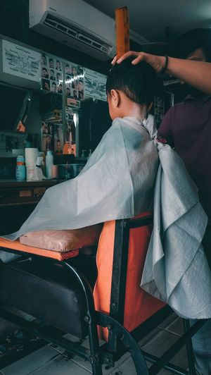 A boy getting his hair cut at the barbershop