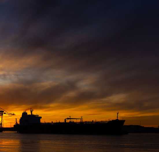 Silhouette ship by sea against sky during sunset