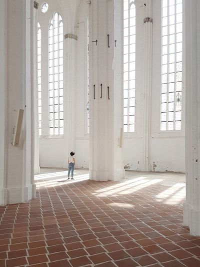 Rear view of woman walking in corridor of building