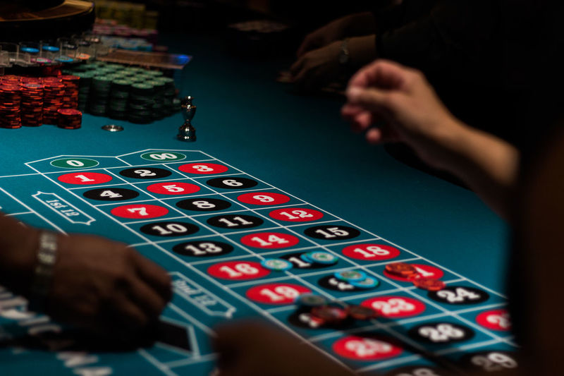 Cropped image of people playing on gambling table in casino