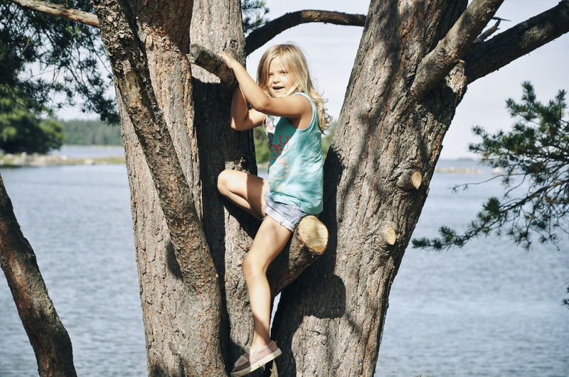 Portrait of happy girl on tree trunk