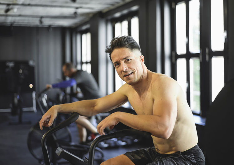 Portrait of shirtless man exercising gym