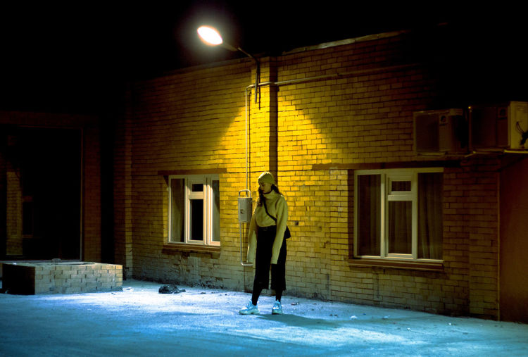Full length of woman standing in illuminated building