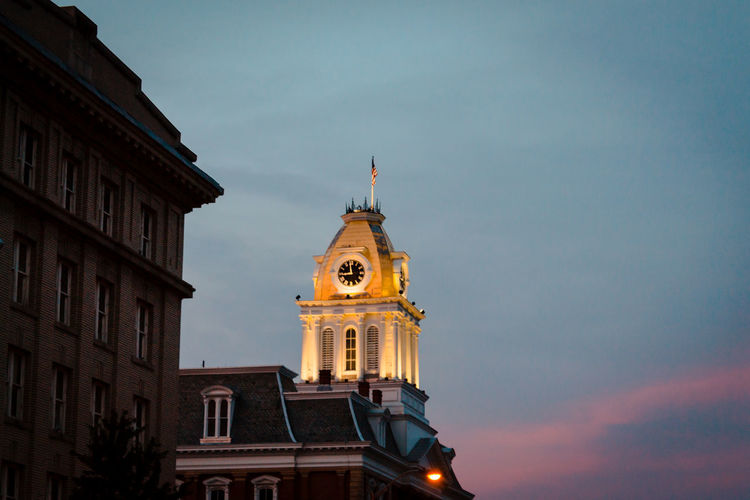 Low angle view of a clock tower on a building in indiana, pa at sunset