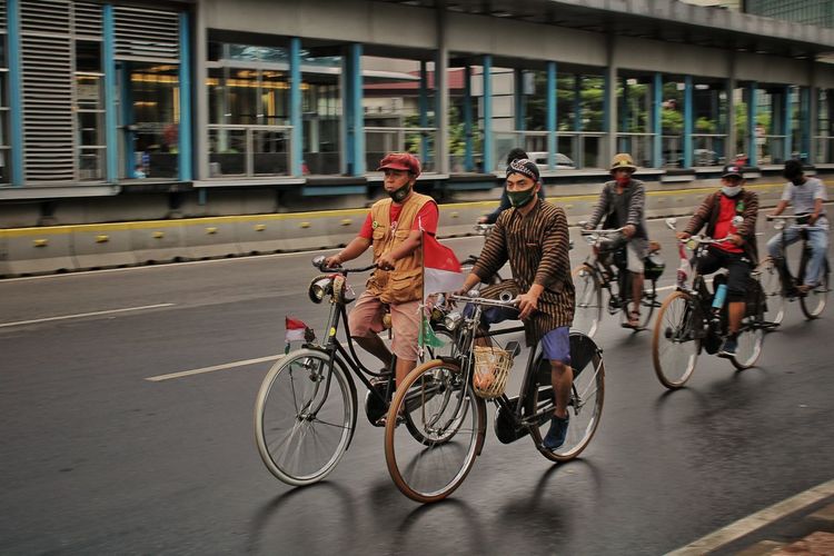 People riding bicycles on road in city