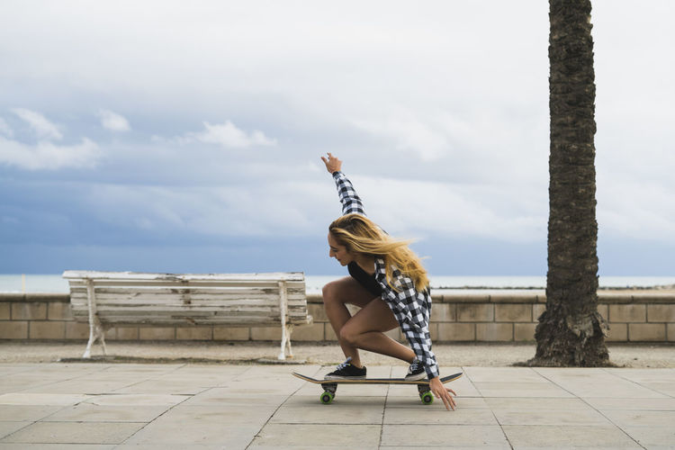 Young woman balancing on skateboard