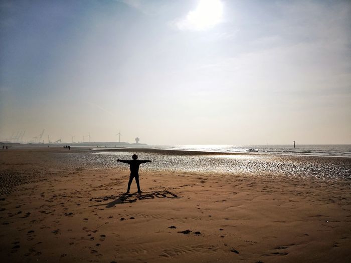 Silhouette person on beach against sky