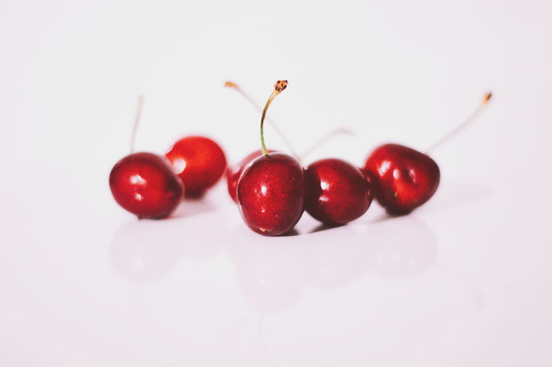 Close-up of cherries over white background