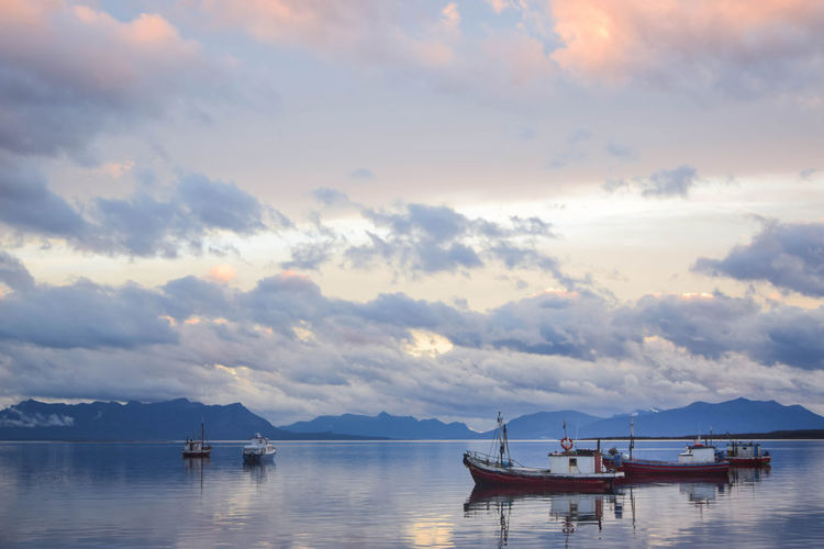 Fishing boats in a quiet bay on a cloudy sunset in patagonia