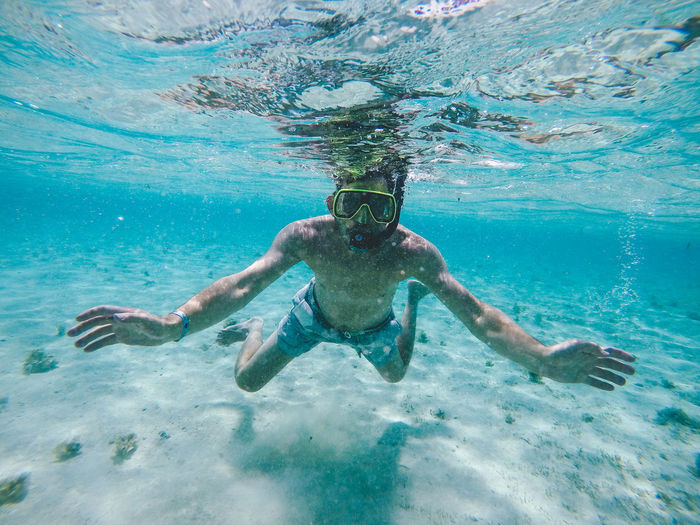 Shirtless man swimming undersea