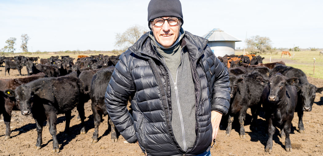 Middle-aged  man isolated on outdoors background with cows in background 
