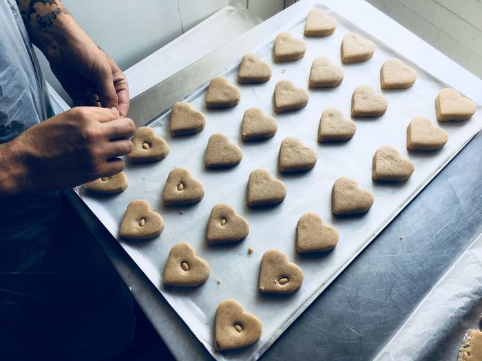 Midsection of male chef preparing heart shape cookies in kitchen