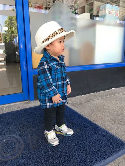 Baby boy wearing hat while standing outdoors