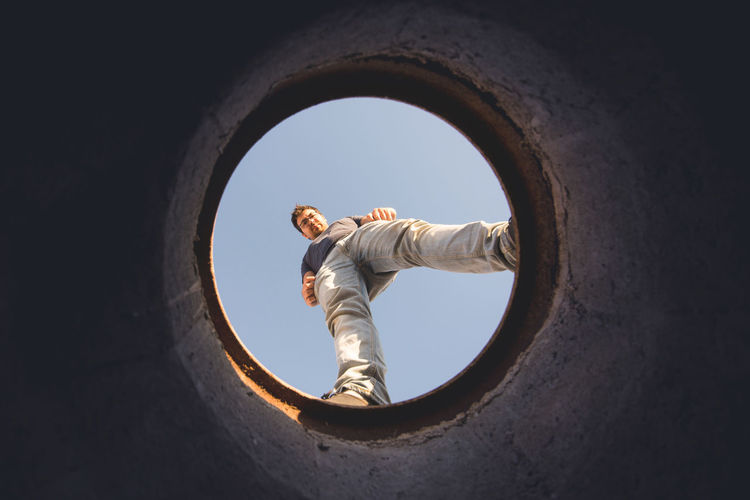 Directly below shot of man seen through hole against sky