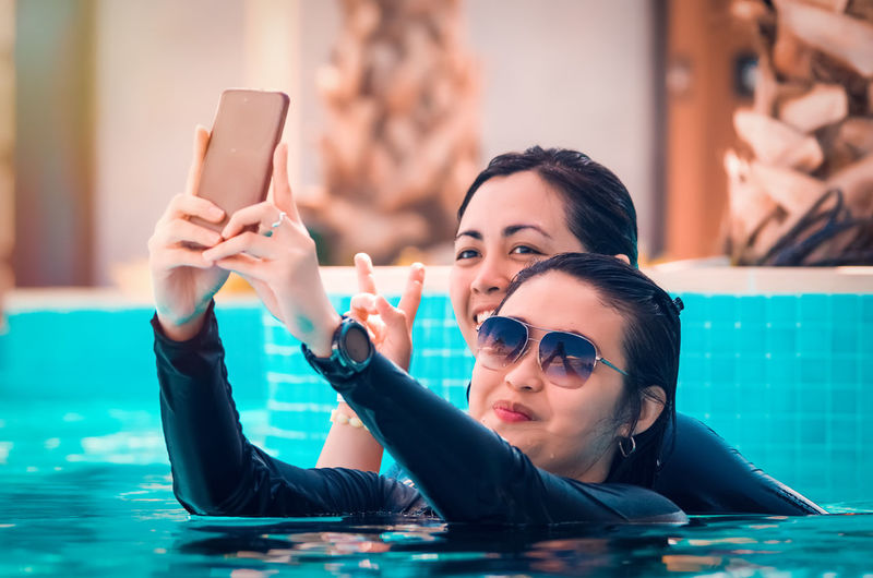 Portrait of woman photographing in swimming pool