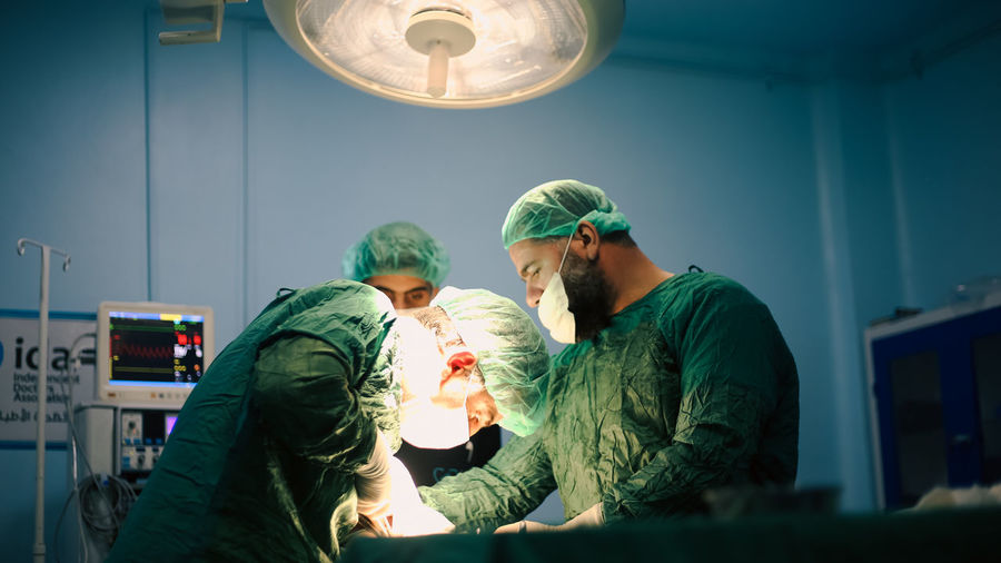 Medical team of surgeons in hospital doing minimal invasive surgical interventions. 