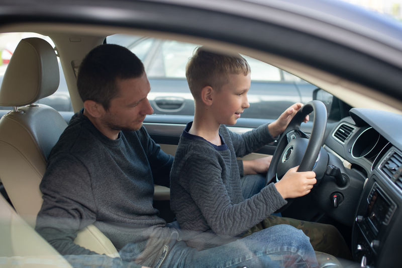 Low section of woman sitting in car