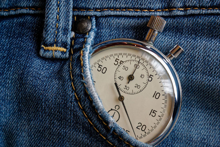 Close-up of stopwatch in jeans pocket