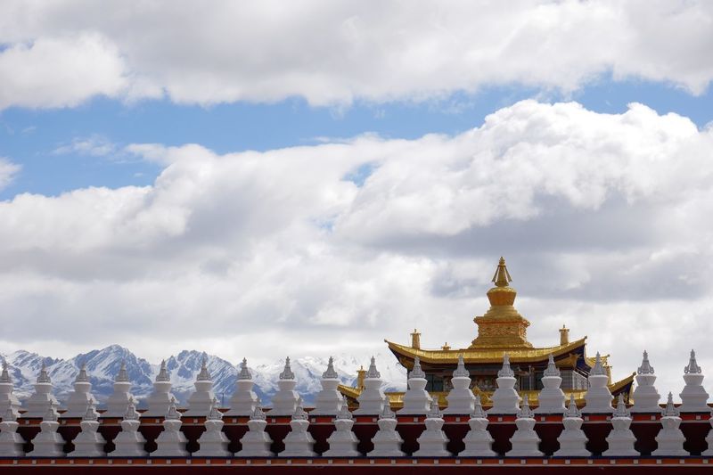 Stupas of building against cloudy sky