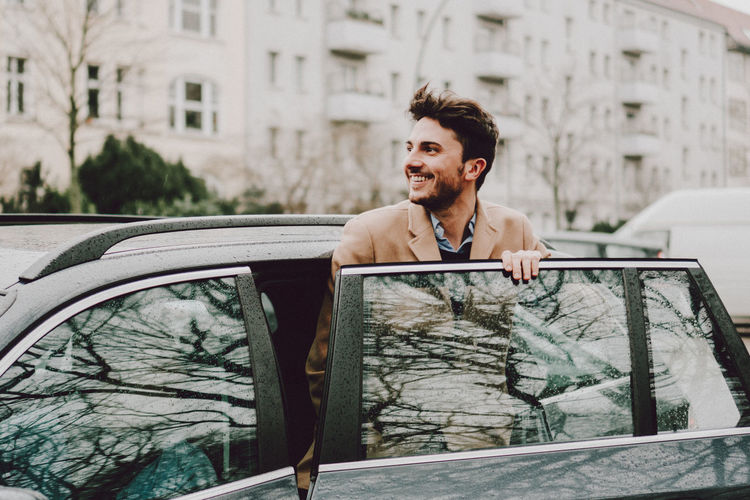 Young man smiling in car