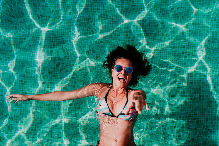 Full length of smiling woman in swimming pool