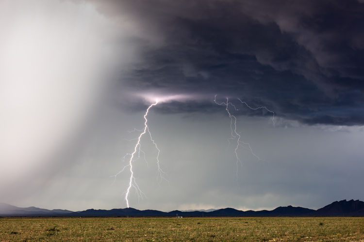 A vivid lightning bolt strikes ahead of an approaching thunderstorm near congress, arizona