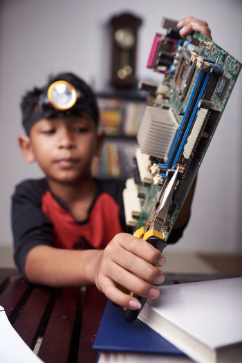 Close-up of boy holding motherboard