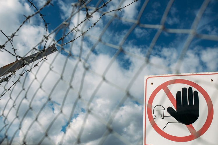 Warning sign on metal fence