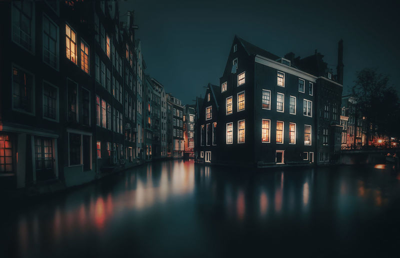 Reflection of buildings on river at night