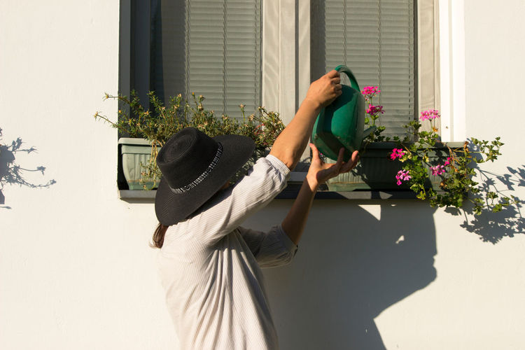 Mature woman watering plant outdoors