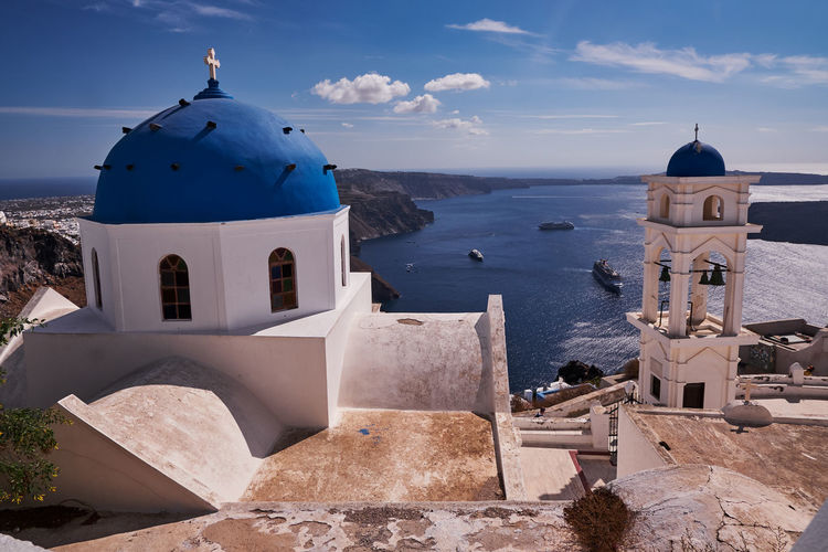 Anastasis church with its blue dome and tower in imerovigli village, santorini, greece