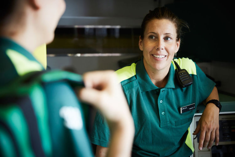 Female paramedics discussing while sitting in ambulance