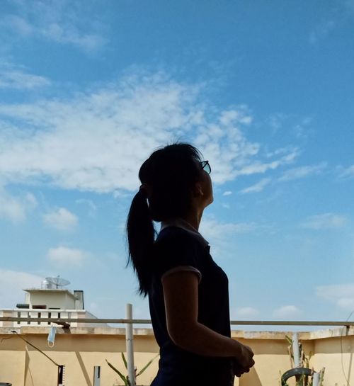 Rear view of woman looking against sky