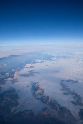 Aerial view of clouds over landscape against blue sky