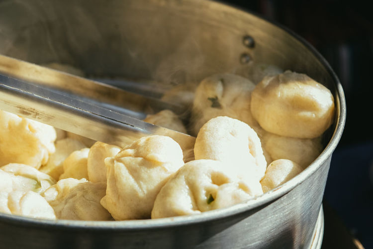 Fresh steamed momo in metal pan at the street tray in the sunlight
