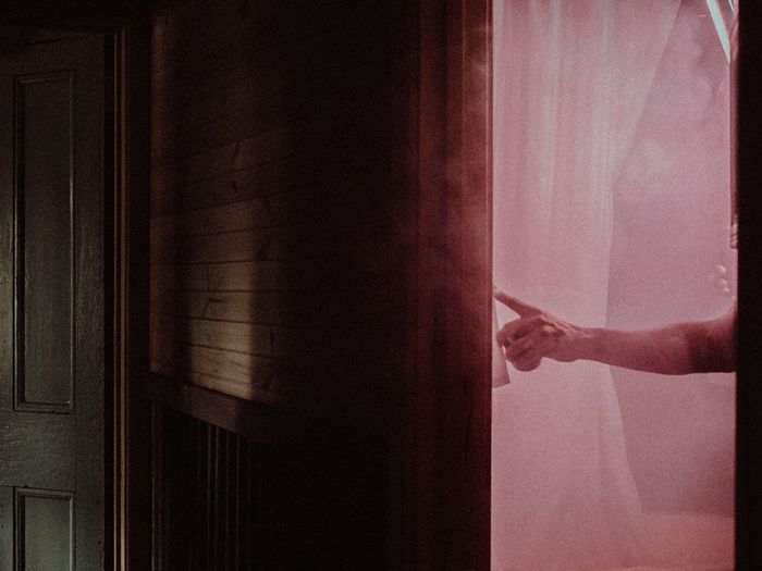 Person standing by window at home