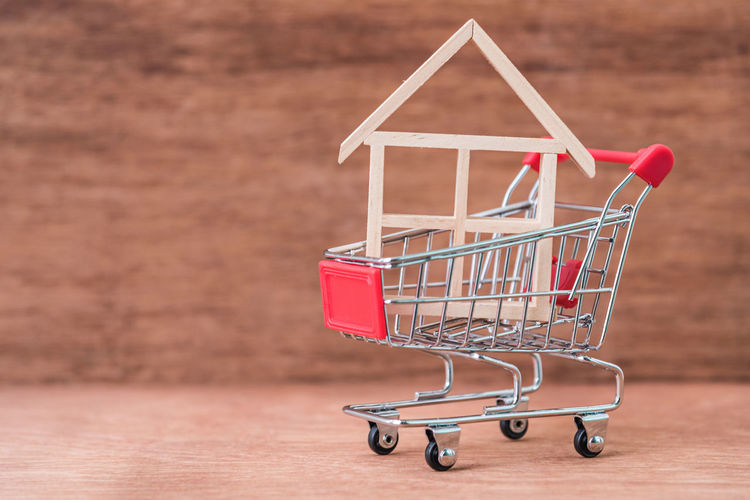 Close-up of model home in shopping cart on table