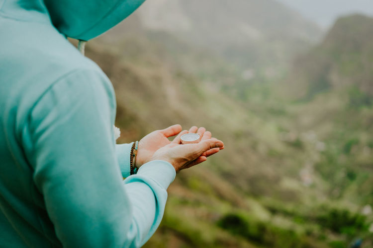 Midsection of woman holding navigational compass