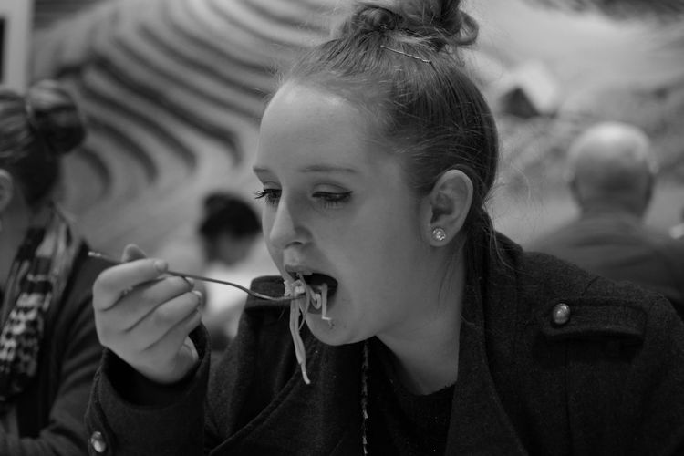 Close-up of woman eating food in restaurant