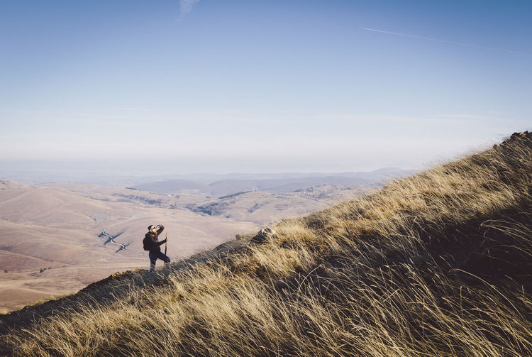 Man standing on landscape against clear sky