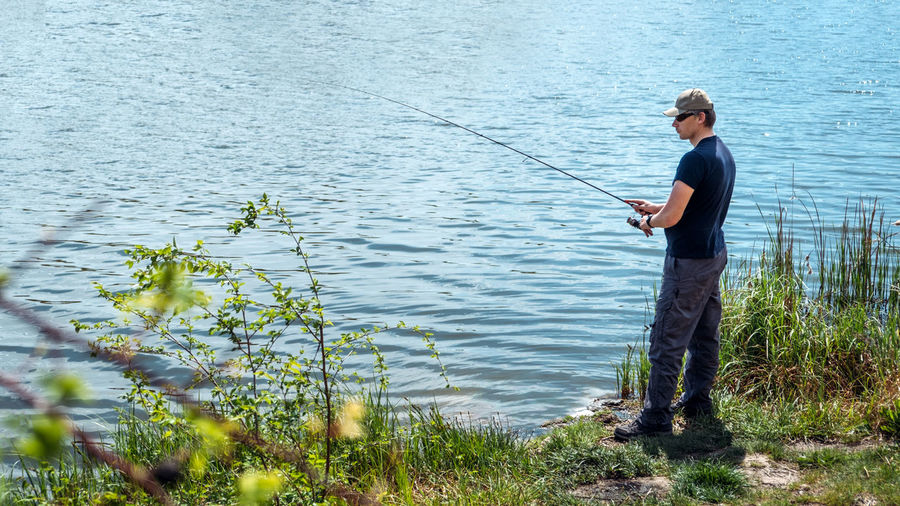 Fisherman with spinning rod on nature background. angler man with fishing spinning 