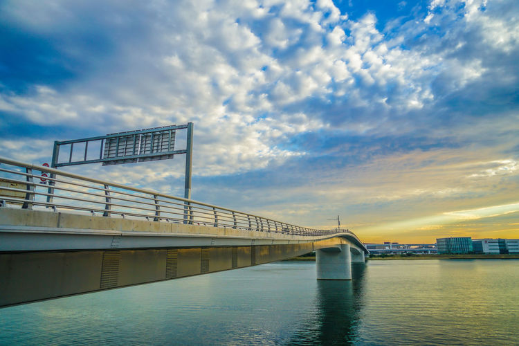 Bridge over river against sky during sunset