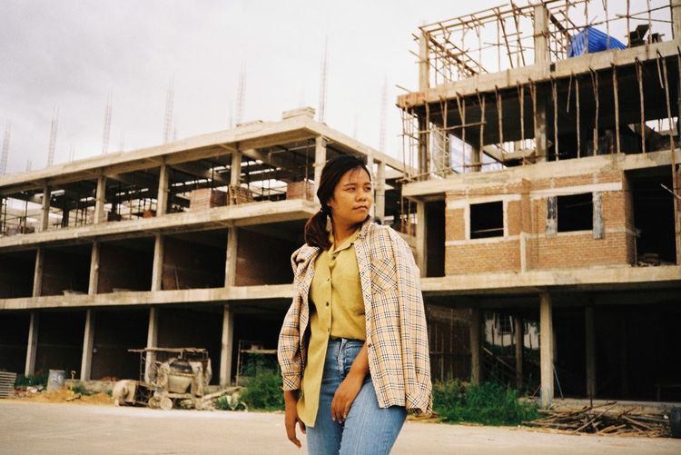 Portrait of woman standing against built structure