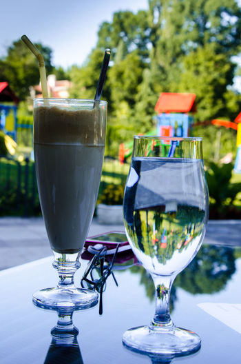 Close-up of coffee and water in glass on outdoors restaurant