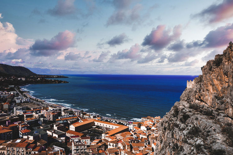High angle view of townscape by sea against sky