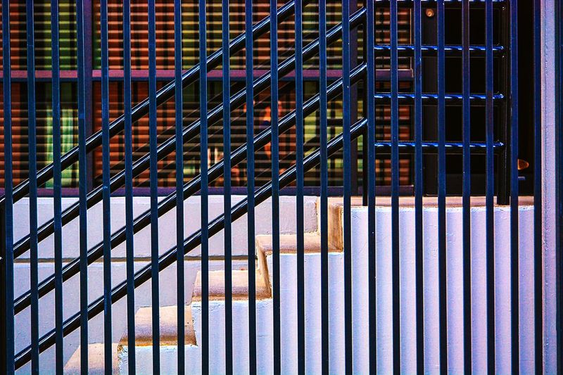 Staircase and railing seen through metal grate