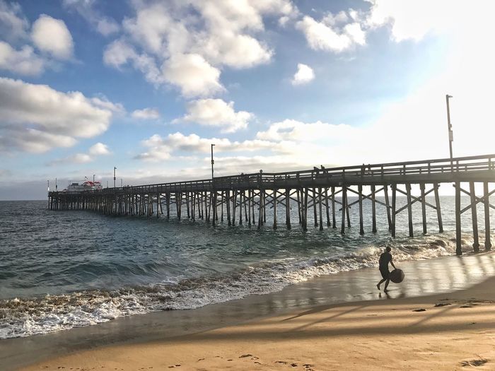 Wooden balboa pier over sea against sky
