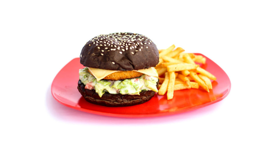 Close-up of burger in plate against white background