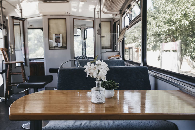 Wooden table inside an old train transformed into a restaurant